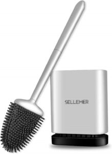 Modern silicone toilet brush with ventilated holder placed beside a white toilet in a contemporary bathroom.