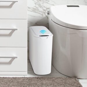 Automatic motion sensor bathroom trash can with lid beside toilet in modern white bathroom.