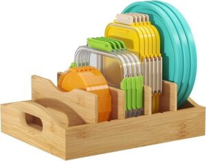Bamboo food container lid organizer with adjustable dividers storing plastic container lids inside a kitchen cabinet.