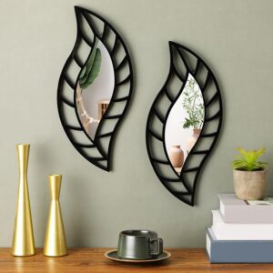 Set of two black leaf-shaped decorative wall mirrors displayed above a wooden console table in a modern living room.
